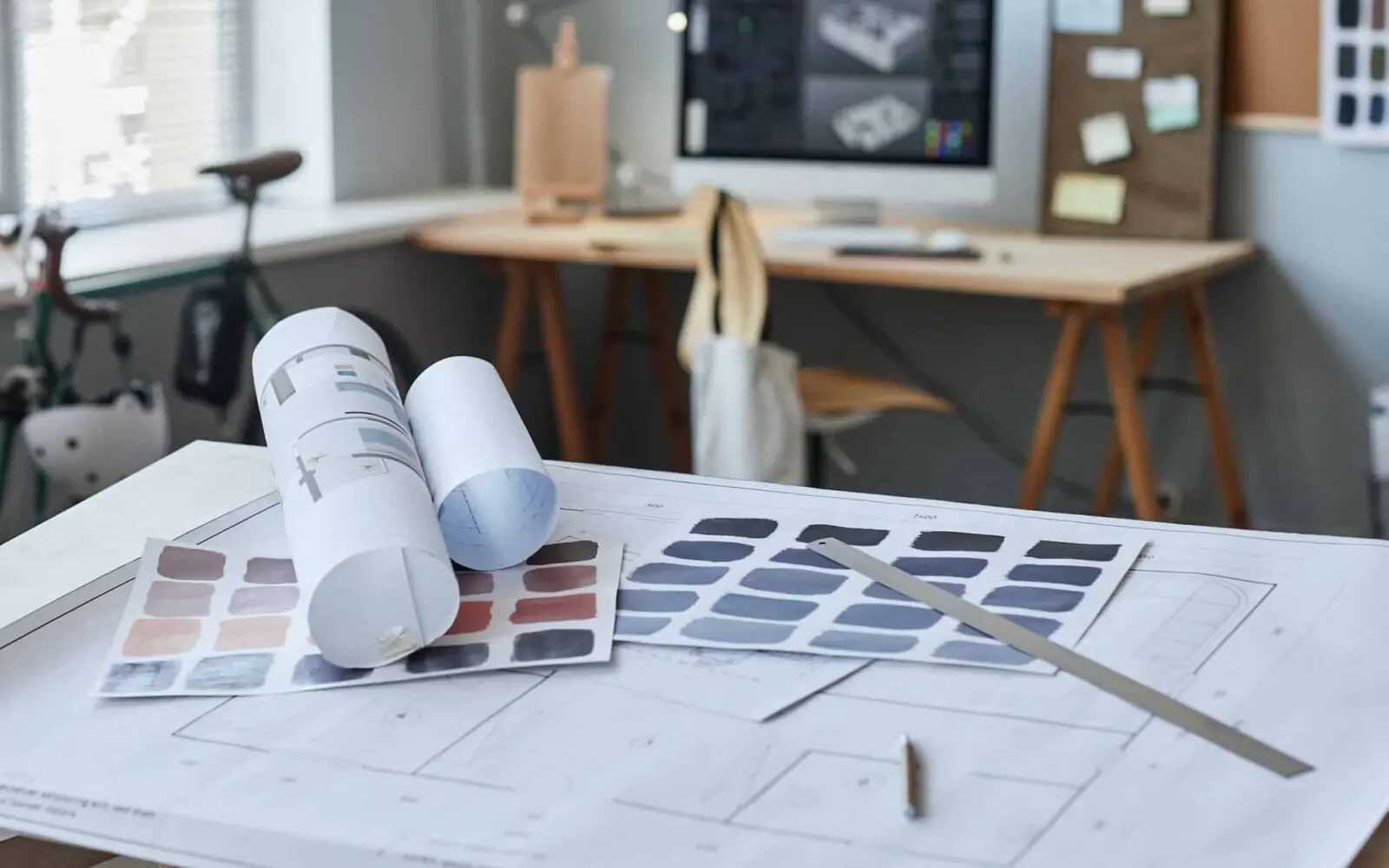 Floor plans and colour swatches laid out on a desk during the design stage of the home renovation process