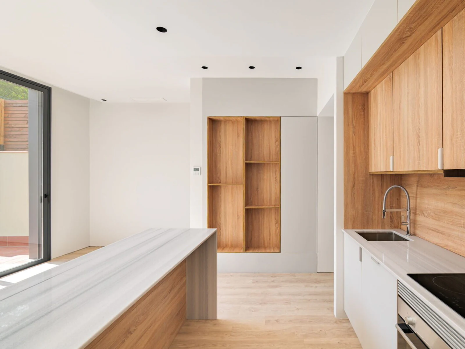 Compact kitchen renovation with dark stone benchtop and integrated appliances