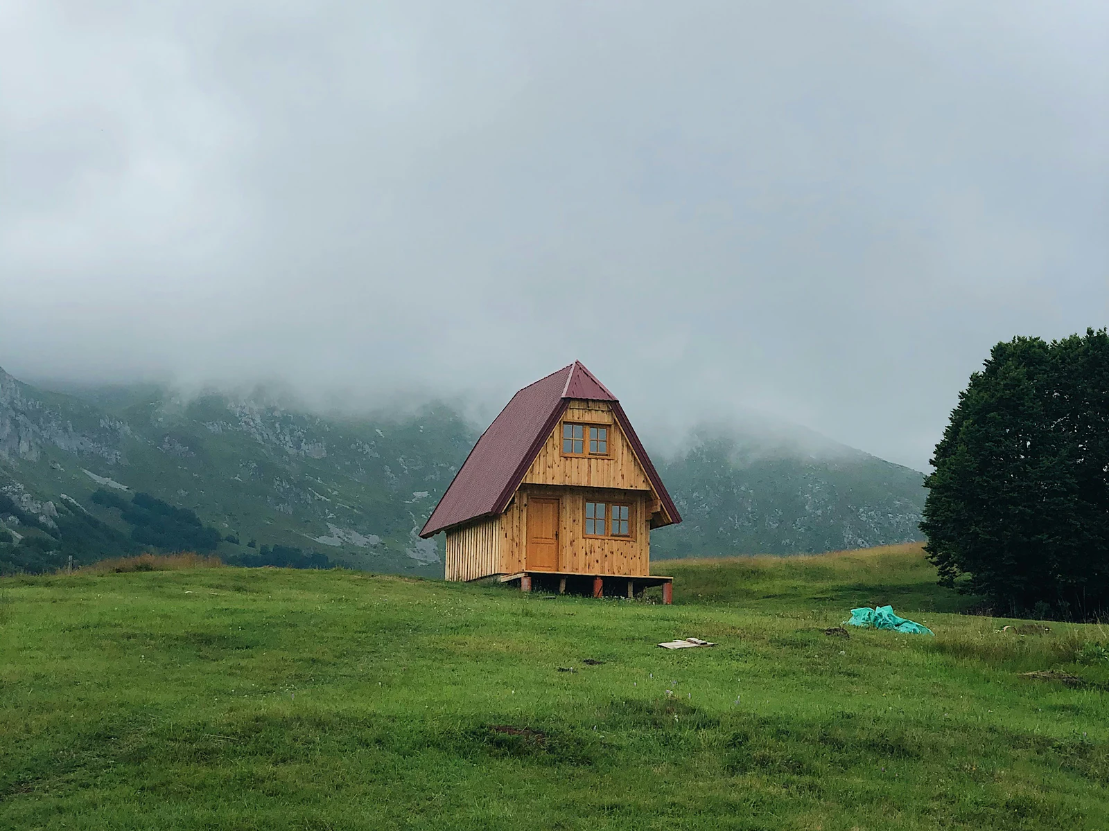 Compact timber-framed cabin with a pitched roof set in open grassland